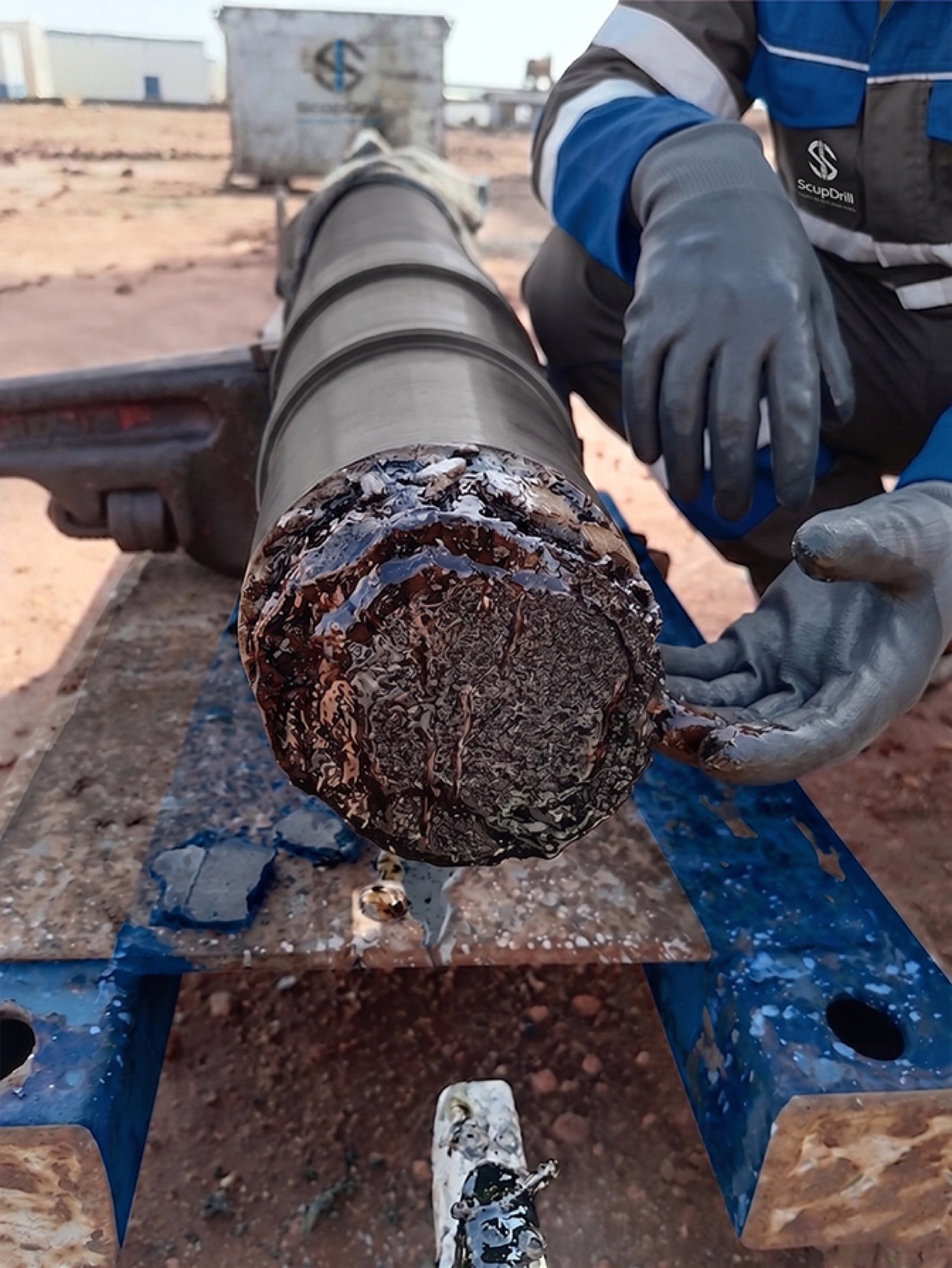Technician handling a wet core sample at the wellsite